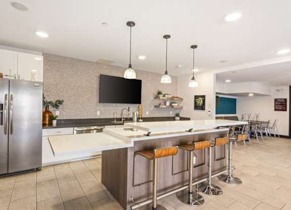 A modern kitchen with a bar area and a refrigerator.