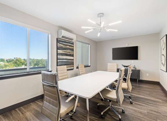 A conference room with a white table and chairs.