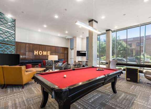 A pool table in a room with a sign that says "HOME".