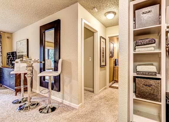 A bathroom with a white chair and a white cabinet.