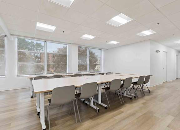 A conference room with a long table and chairs.