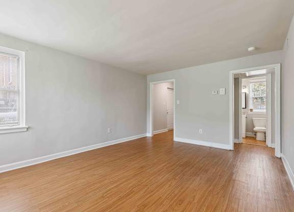 Empty room with wooden floors and white walls.