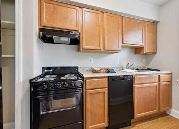 A kitchen with wooden cabinets and black appliances.