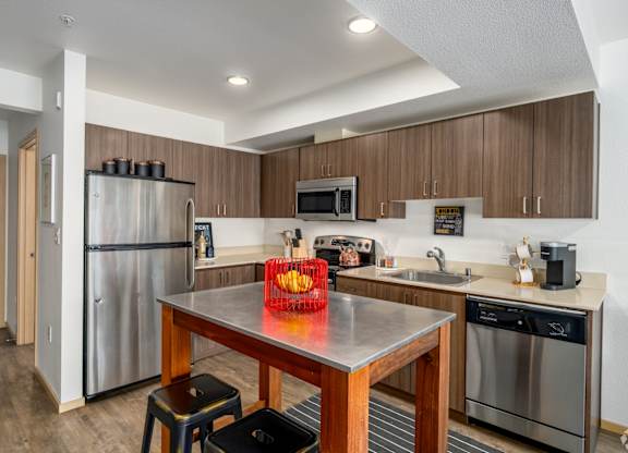 A kitchen with a stainless steel refrigerator, microwave, and dishwasher.