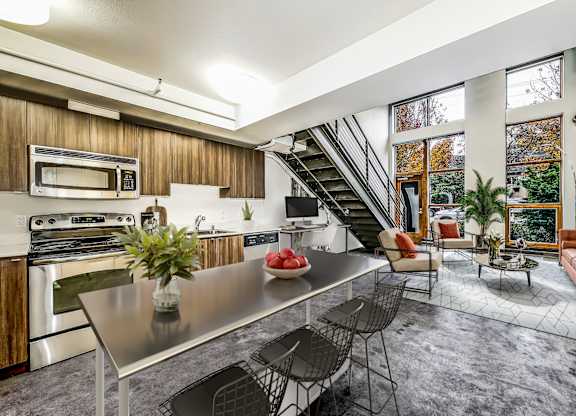 A modern kitchen with a stainless steel table and chairs.
