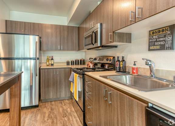 A modern kitchen with wooden cabinets and stainless steel appliances.