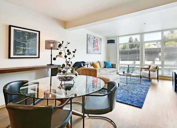 A modern living room with a glass table and chairs.