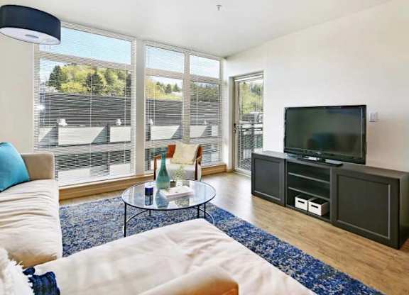 A living room with a white couch and a black coffee table.