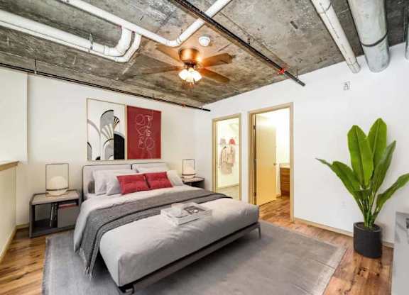 A bedroom with a large bed and a ceiling fan.