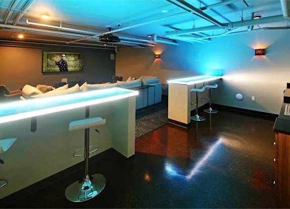 A room with a bar and a painting on the wall.