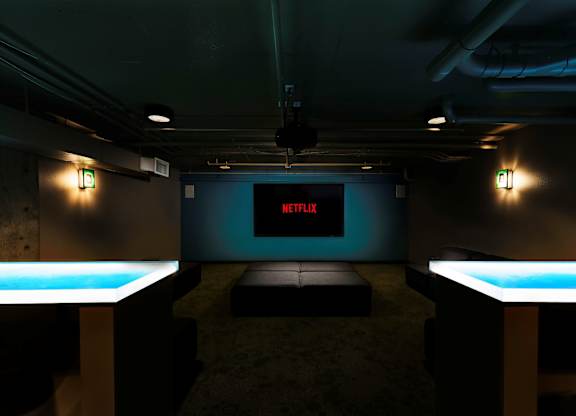 A room with a screen displaying the Netflix logo.