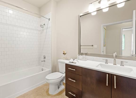 Spacious bathroom with tiled shower, bathtub, and updated vanity area with above-mirror lighting at Sylvan Uptown,Colorado, Denver