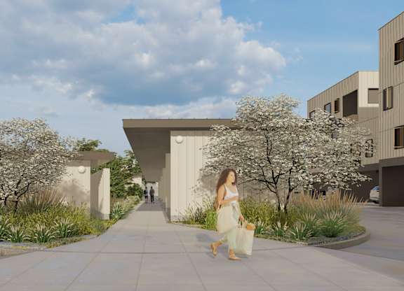 A woman in a white dress is walking down a sidewalk in front of a modern building.