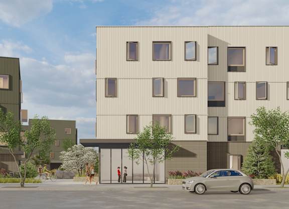 A modern building with a grey car parked in front.