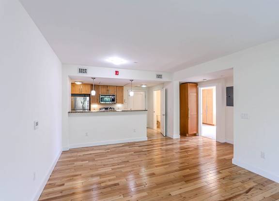 A spacious room with wooden floors and white walls at Park87 Apartments, Massachusetts, 02138