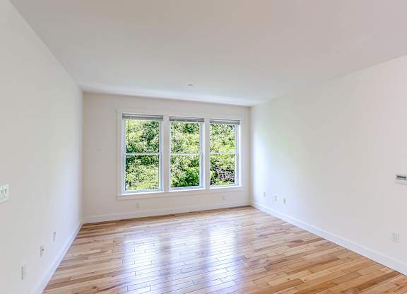 A room with wooden floors and a large window at Park87 Apartments, Cambridge 02138