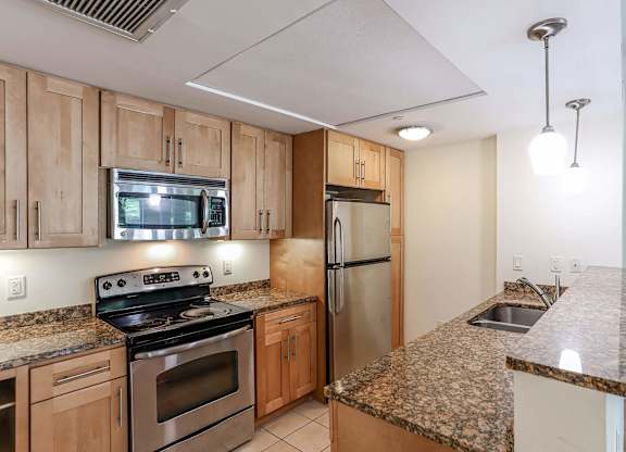 A kitchen with granite countertops and stainless steel appliances at Park87 Apartments, Massachusetts
