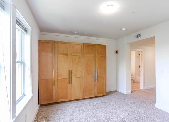 A room with a set of wooden doors and a carpeted floor at Park87 Apartments, Massachusetts