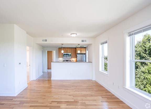 A spacious room with wooden floors and white walls at Park87 Apartments, Cambridge