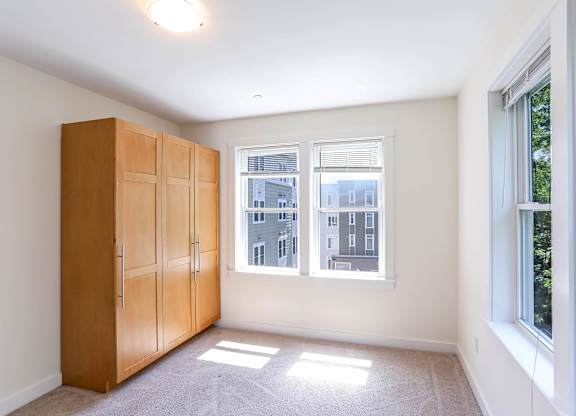 A room with a large window and a wooden cabinet. at Park87 Apartments, Cambridge, MA, 02138