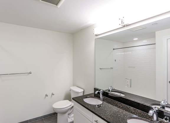 A white bathroom with a toilet, sink, and shower at 7 Cameron Apartments, Massachusetts