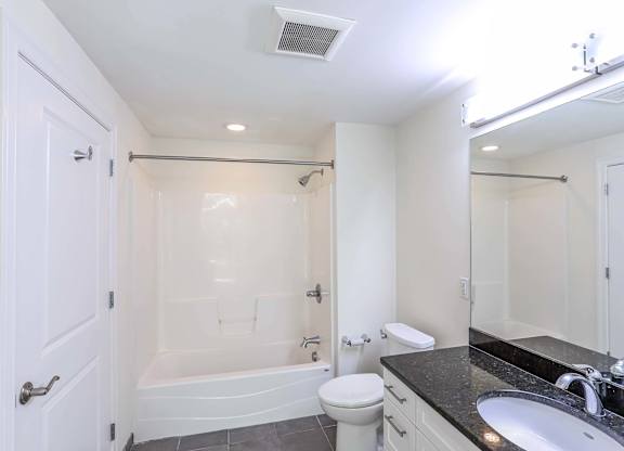 An updated bathroom with a black counter top and shower at 7 Cameron Apartments, Cambridge, MA, 02140