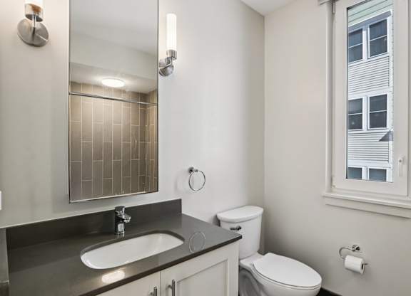 Bathroom with a sink and mirror at Park77 Apartments, Cambridge