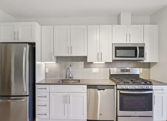 Beautiful kitchen with white cabinets and refrigerator at Park77 Apartments, Massachusetts