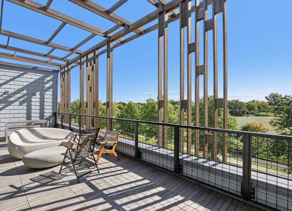 Wooden deck with a metal railing and a chair at Park77 Apartments, Cambridge, Massachusetts