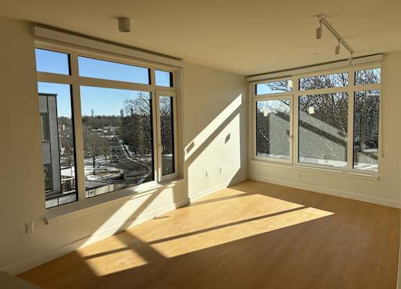 A room with a large window and wooden floors. at 605 Concord at Fresh Pond Apartments, Cambridge, MA