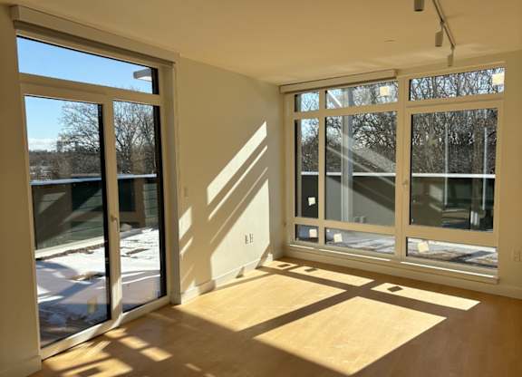 A sunny day with a view of trees through the window at 605 Concord at Fresh Pond Apartments, Cambridge