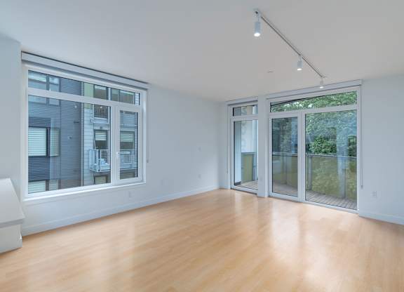 A spacious room with wooden floors and large windows at 605 Concord at Fresh Pond, Cambridge