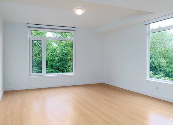 A room with a large window and wooden flooring  at 605 Concord at Fresh Pond Apartments, Massachusetts