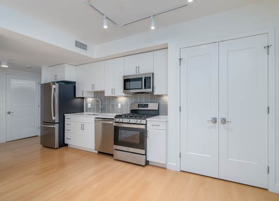 A kitchen with white cabinets and stainless steel appliances  at 605 Concord at Fresh Pond Apartments, Massachusetts
