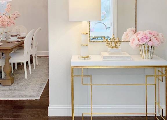 a white desk with a mirror and a table with a chair