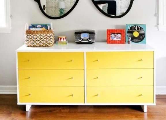 a dresser with a large pair of glasses on the wall
