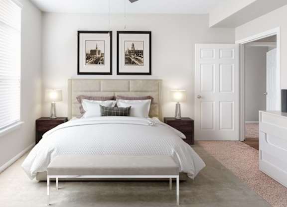 A bedroom with a large bed and two pictures on the wall.