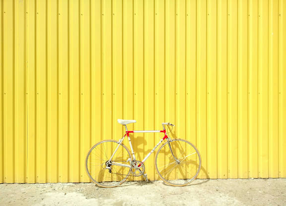 a bike parked in front of a yellow wall