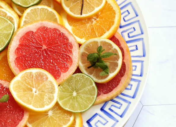 a plate of citrus fruit on a wooden cutting board