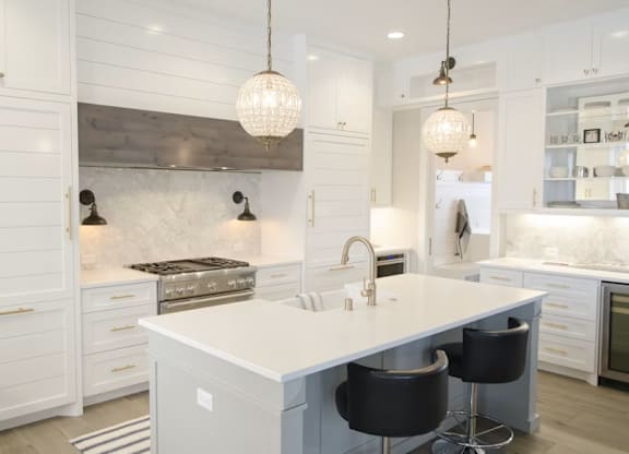 A modern kitchen with a large island and bar stools.