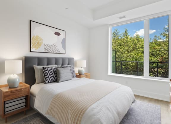 A bedroom with a large bed and a painting above it.