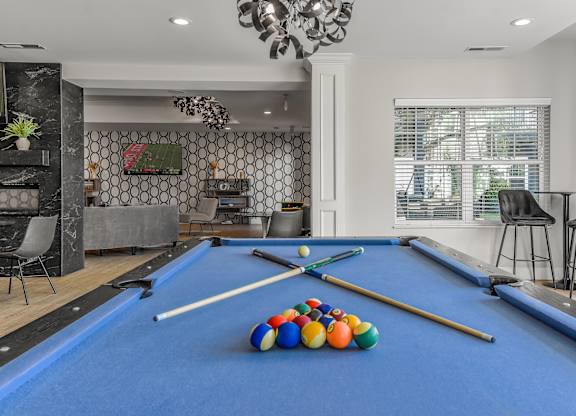 a game room with a pool table and billiard balls