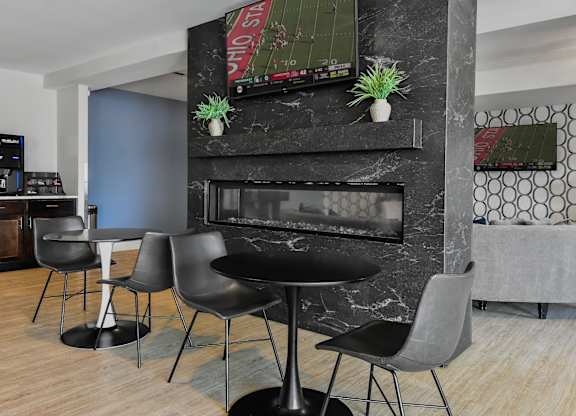 a living room with a fireplace and tables and chairs