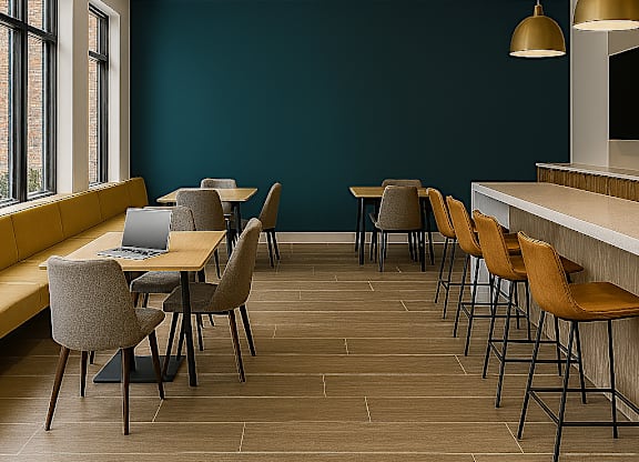 A room with a long table and chairs with a laptop on it.