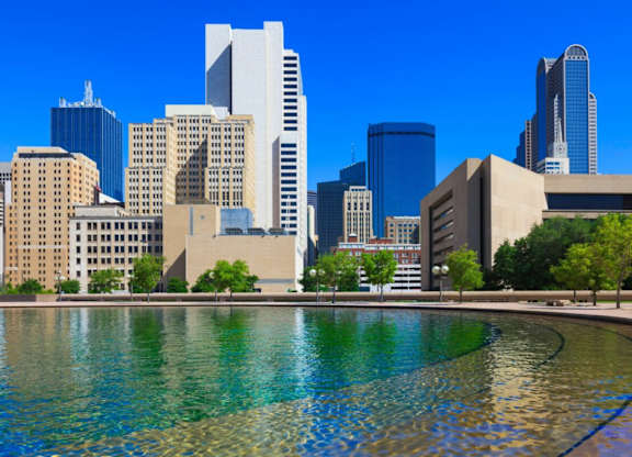 A cityscape with a large body of water in the foreground.