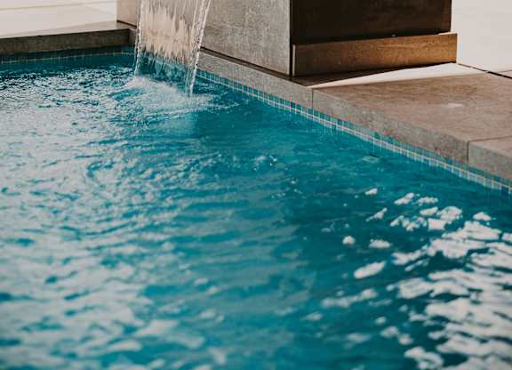 A pool with a waterfall feature in the middle.