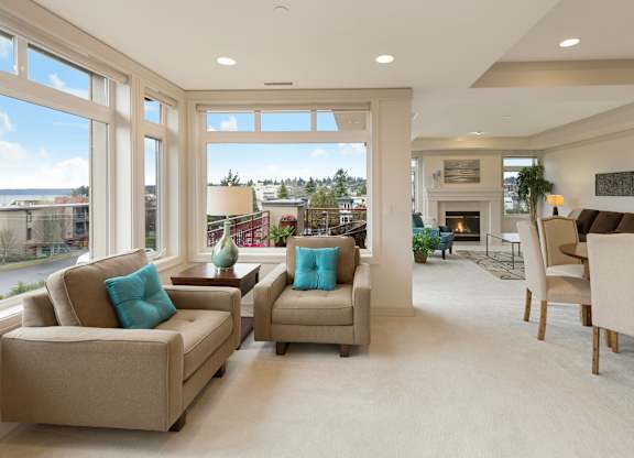 A living room with a fireplace and a view of the street outside.