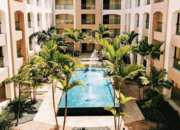 a swimming pool in the middle of a building with palm trees