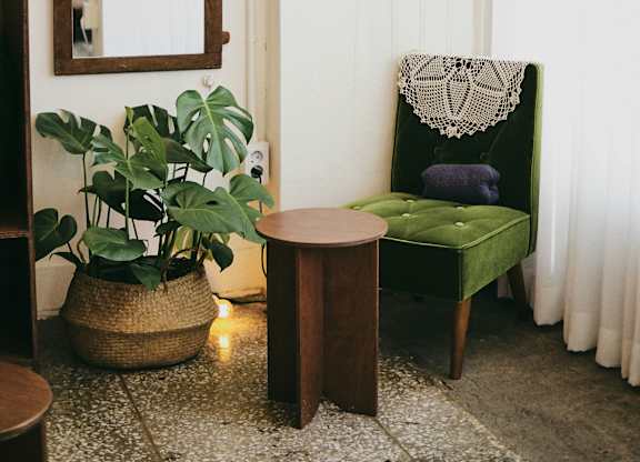 a living room with a green chair and a mirror