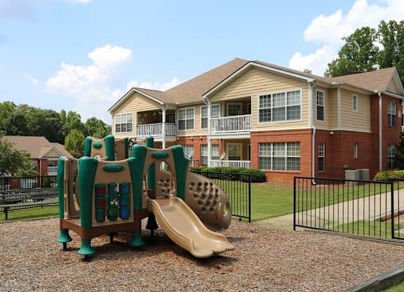 a playground with a slide in front of an apartment building